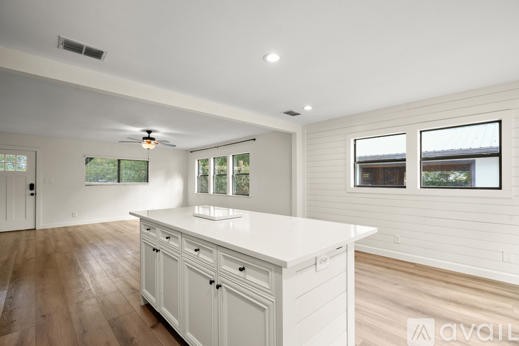 A kitchen with white cabinets and a large island.