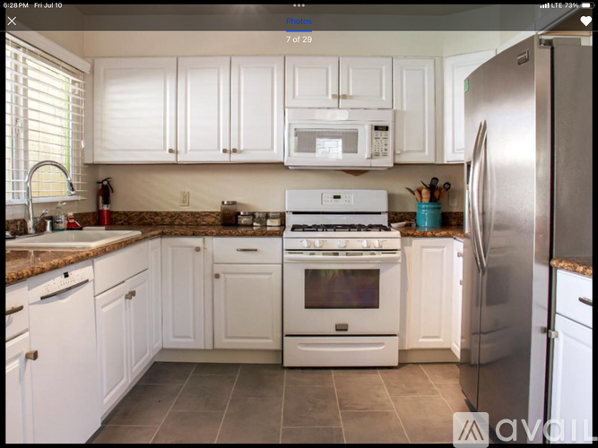 A kitchen with white cabinets and appliances.