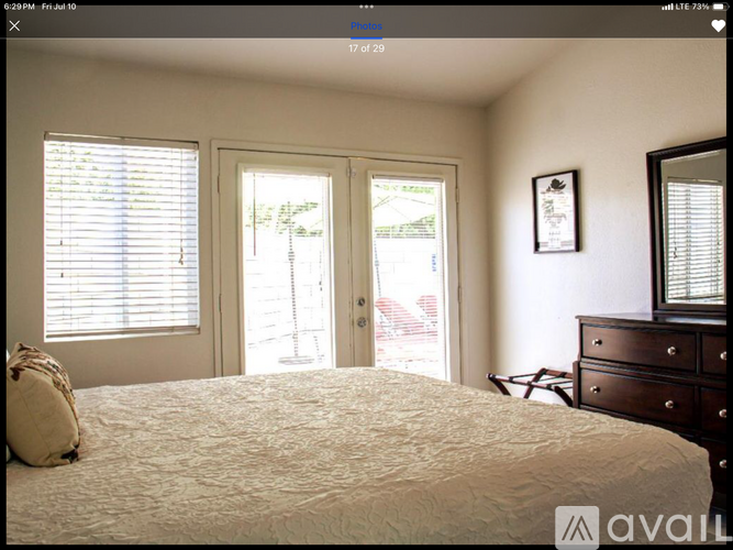 A bedroom with a bed, dresser, and mirror.