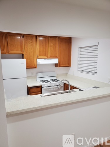 A kitchen with wooden cabinets and white appliances.