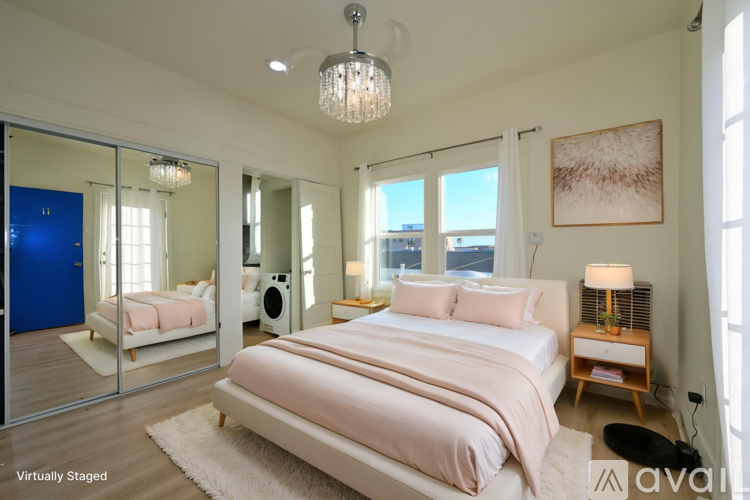 A bedroom with a large bed and a chandelier.