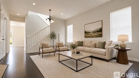 A living room with a white couch, a coffee table, and a painting on the wall.