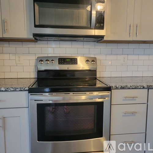 A stainless steel oven with a digital display is on a kitchen counter.