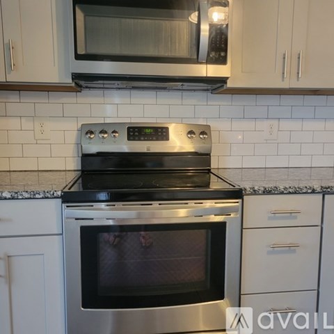 A stainless steel oven with a digital display is on a kitchen counter.