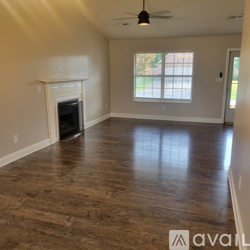 A living room with a fireplace and wood flooring.