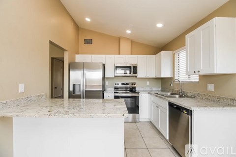 A kitchen with white cabinets and granite countertops.