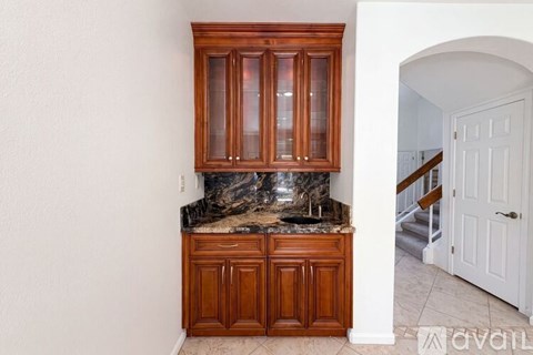 A kitchen with wooden cabinets and a marble countertop.