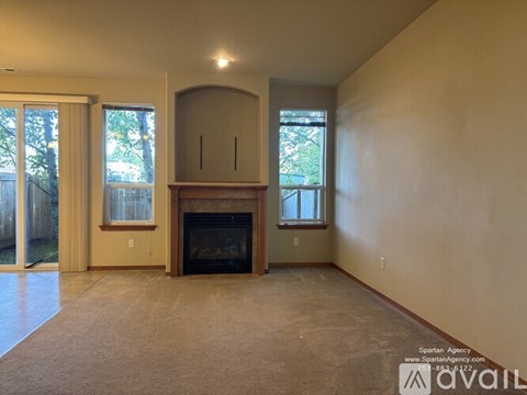 A living room with a fireplace and a window.