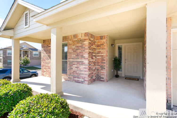 A house with a white garage door and a brick pillar.