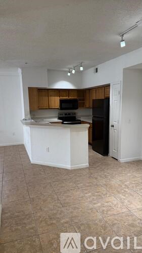 A kitchen with a black refrigerator and a white counter.