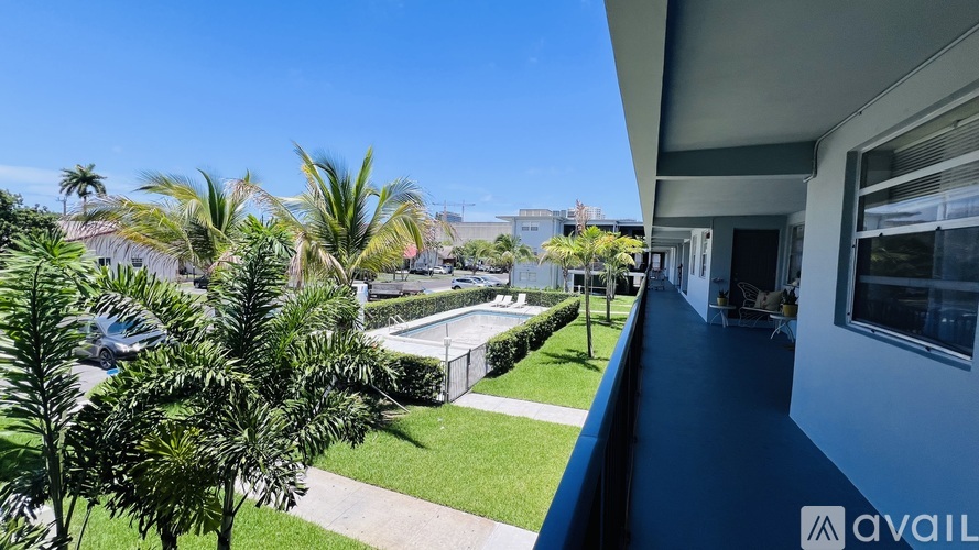A balcony with a view of a pool and palm trees.