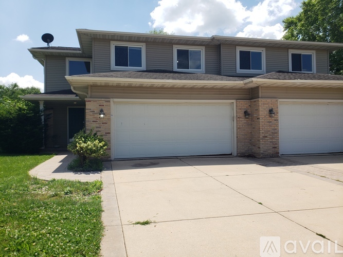 A house with a garage and a driveway in front.