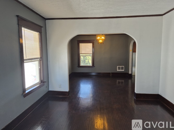 A room with a window and a wooden floor.