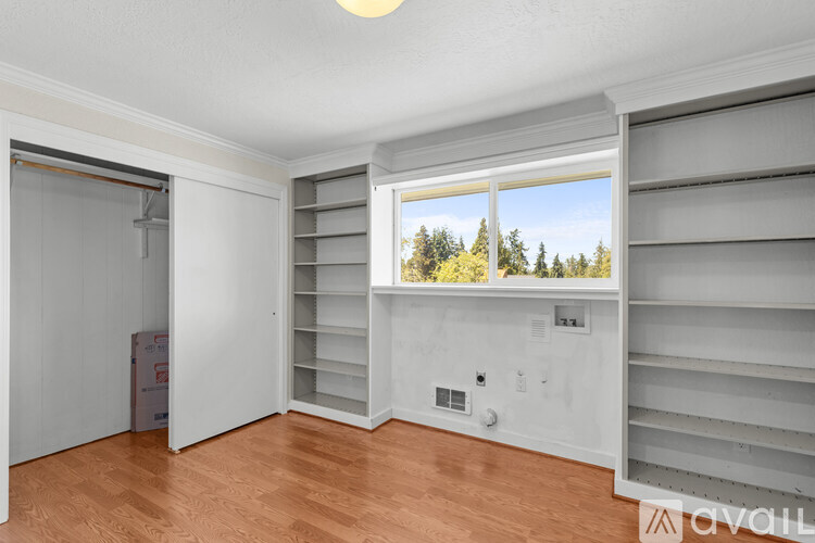 A room with a window showing trees outside.