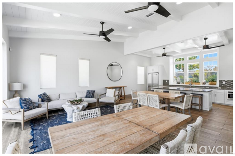 A modern living room with a wooden table and white furniture.
