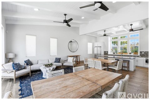 A modern living room with a wooden table and white furniture.