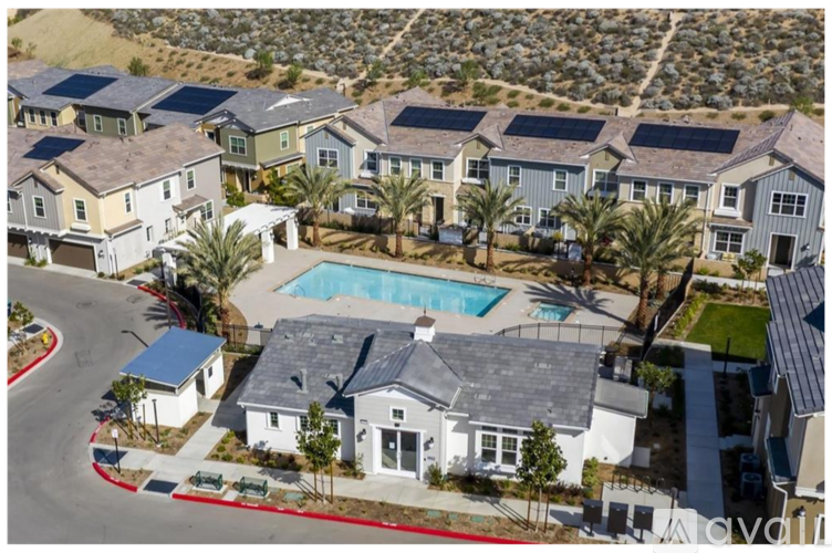 A bird's eye view of a residential area with houses and a swimming pool.