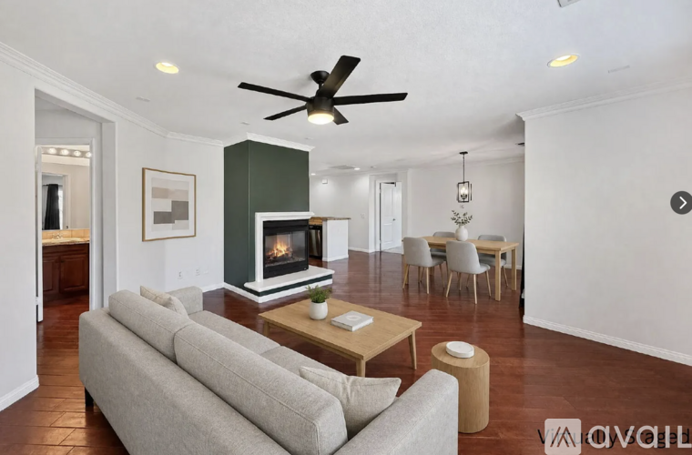 A living room with a grey couch and a wooden coffee table.