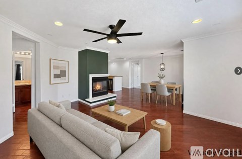 A living room with a grey couch and a wooden coffee table.