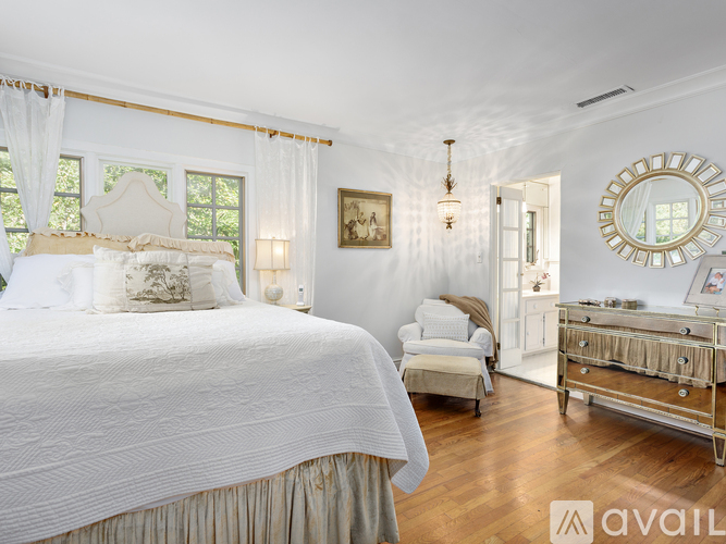 A bedroom with a large bed and a dresser.