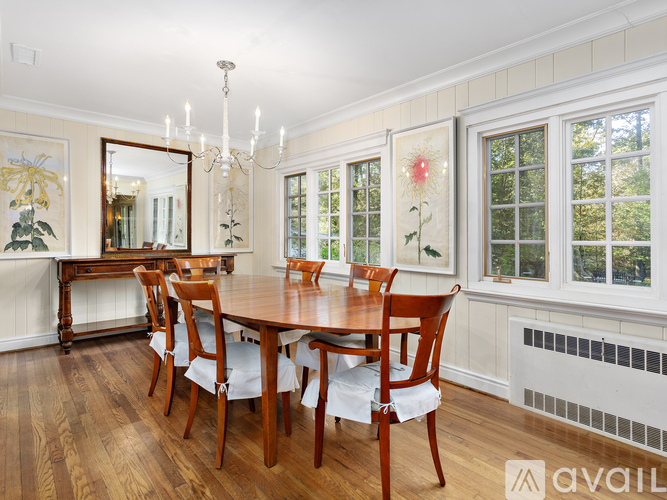 A dining room with a wooden table and chairs.