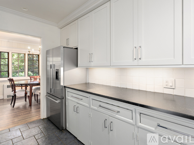 A kitchen with white cabinets and a black countertop.