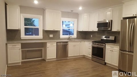 A kitchen with white cabinets and stainless steel appliances.
