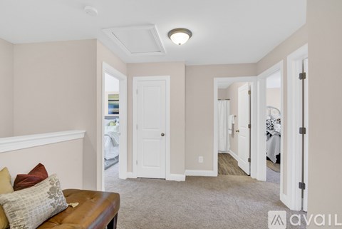 A living room with a brown couch and a white door.