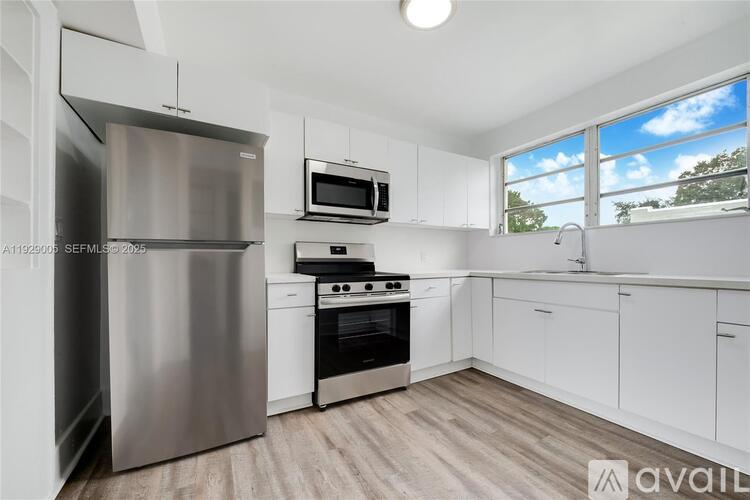 A modern kitchen with stainless steel appliances and white cabinetry.