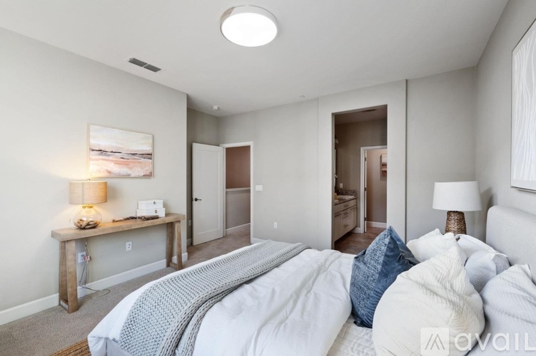 A bedroom with a large bed and a painting on the wall.