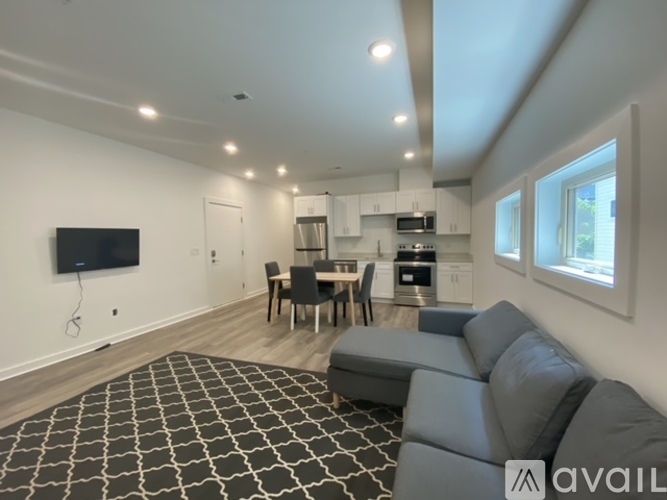 A living room with a grey sofa and a black and white patterned rug.