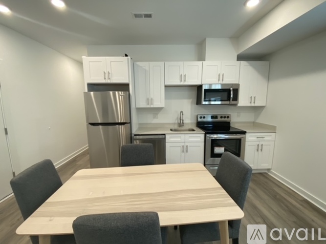 A kitchen with a table and chairs in front of it.