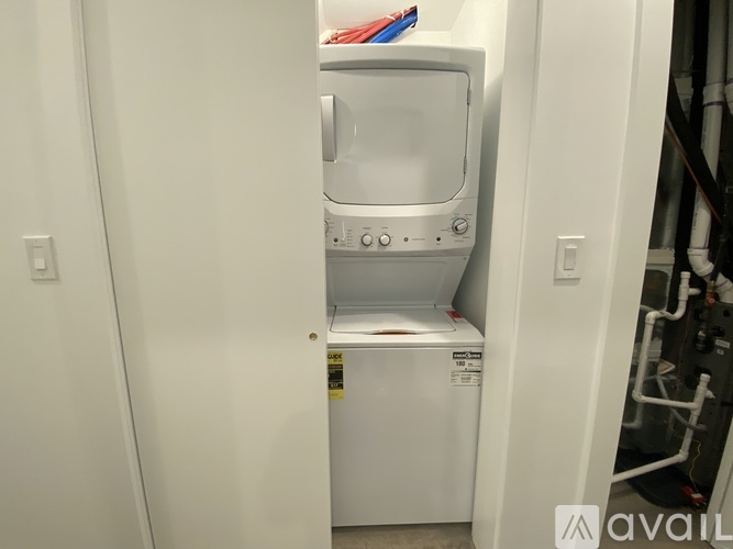 A white washing machine is sitting in a small space.
