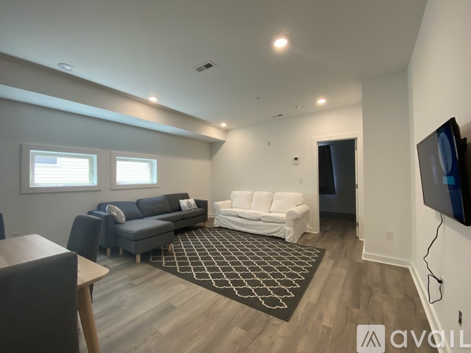 A living room with a grey couch and a white couch.