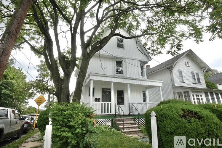 A white house with a black door and a porch.