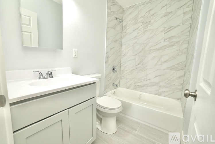 A bathroom with a marble wallpaper and a white toilet.