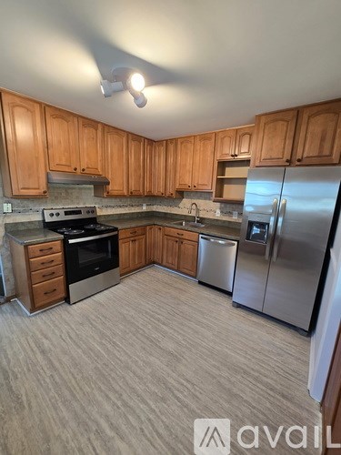 A kitchen with wooden cabinets and a refrigerator.