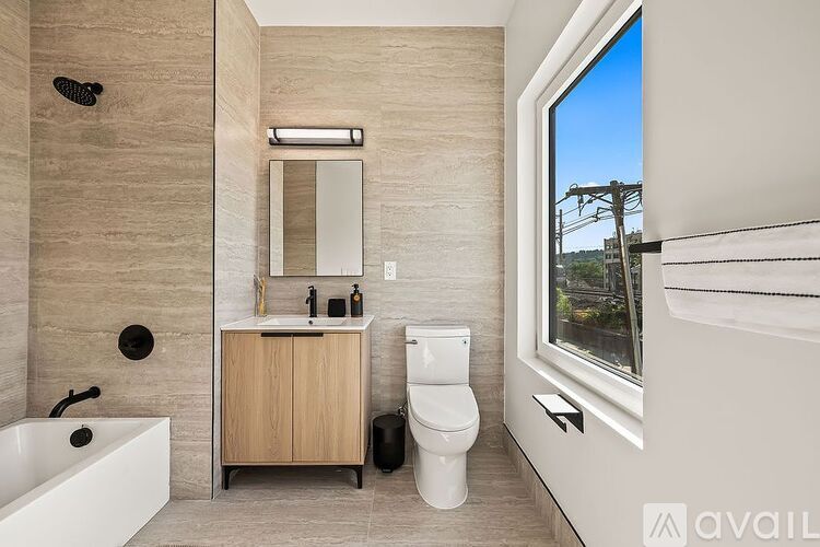 A bathroom with a tub, toilet, sink, and mirror.