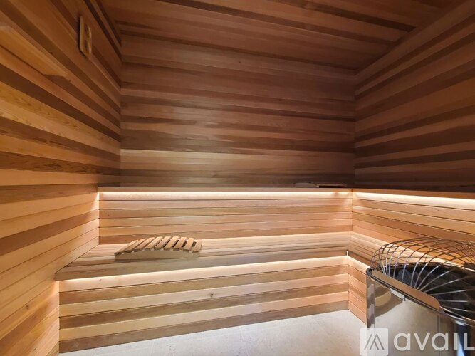 A wooden sauna with benches and lighting.