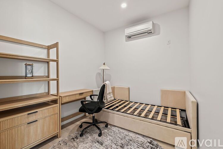 A room with a bed, desk, and chair.