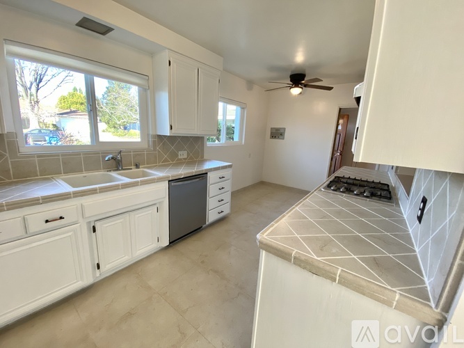 A kitchen with white cabinets and a tiled backsplash.