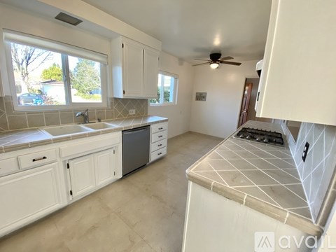 A kitchen with white cabinets and a tiled backsplash.
