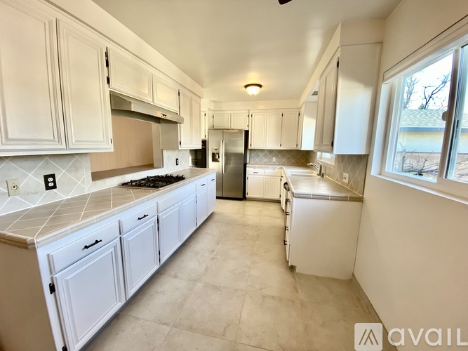 A kitchen with white cabinets and appliances.