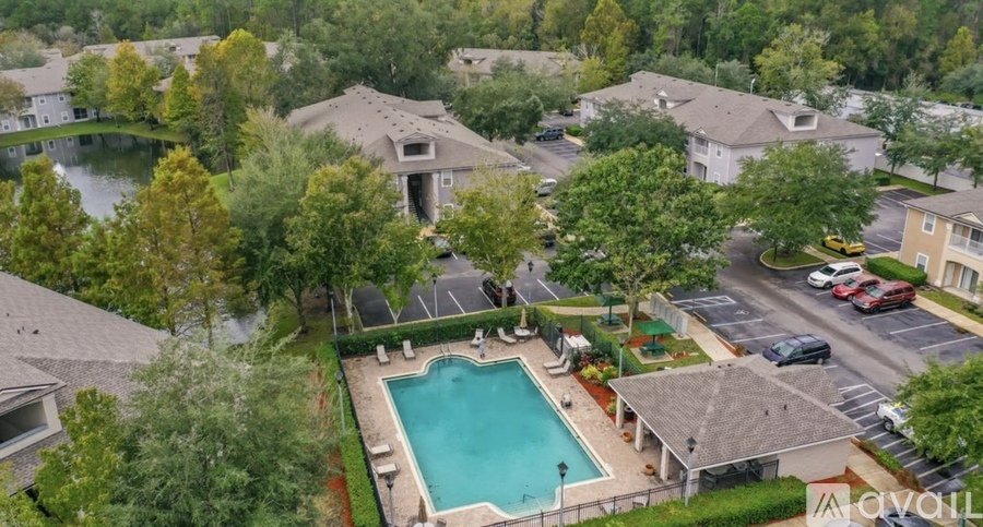 A bird's eye view of a residential area with houses, a swimming pool, and a parking lot.