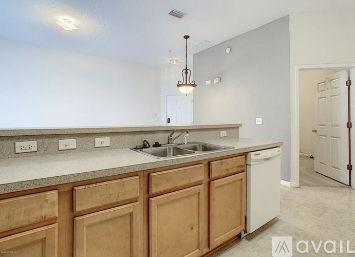 A kitchen with wooden cabinets and a white sink.