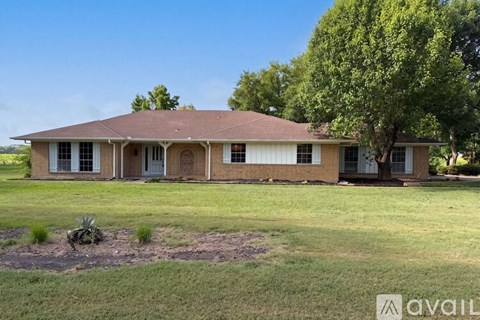 A house with a brown roof and a tree in front.