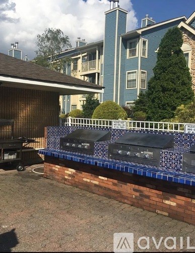 A BBQ grill is on a brick wall with a blue tile border.