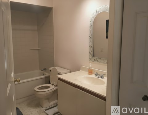 A bathroom with a toilet, sink, and mirror.