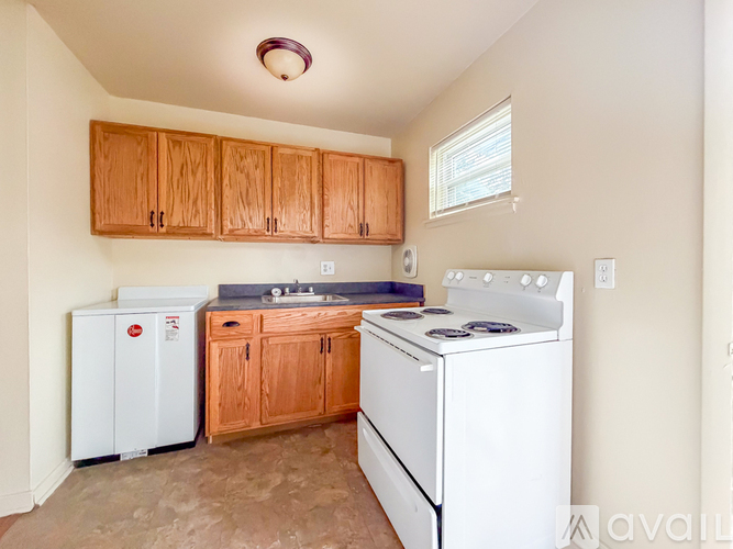 A kitchen with a white stove and wooden cabinets.