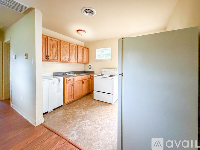 A kitchen with white appliances and wooden cabinets.